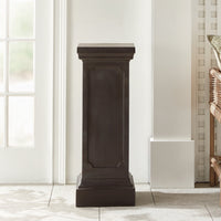 The Fibreclay Chambers Pedestal by Napa Home & Garden with an antique black finish stands near a window and wicker chair.
