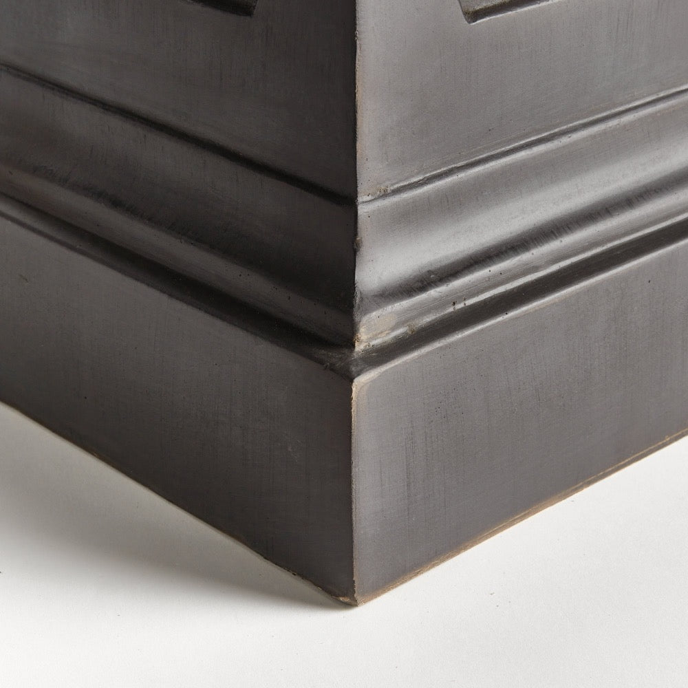 Close-up of the Napa Home & Garden Fibreclay Chambers Pedestal, featuring an ornate black finish on a white floor.