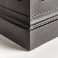 Close-up of the Napa Home & Garden Fibreclay Chambers Pedestal, featuring an ornate black finish on a white floor.