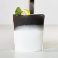 A layered black and white dessert in a Santa Barbara Design Studio Resin Two Tone Tumbler, topped with lemon and mint.
