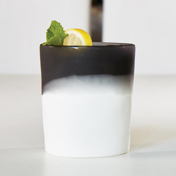 A layered black and white dessert in a Santa Barbara Design Studio Resin Two Tone Tumbler, topped with lemon and mint.