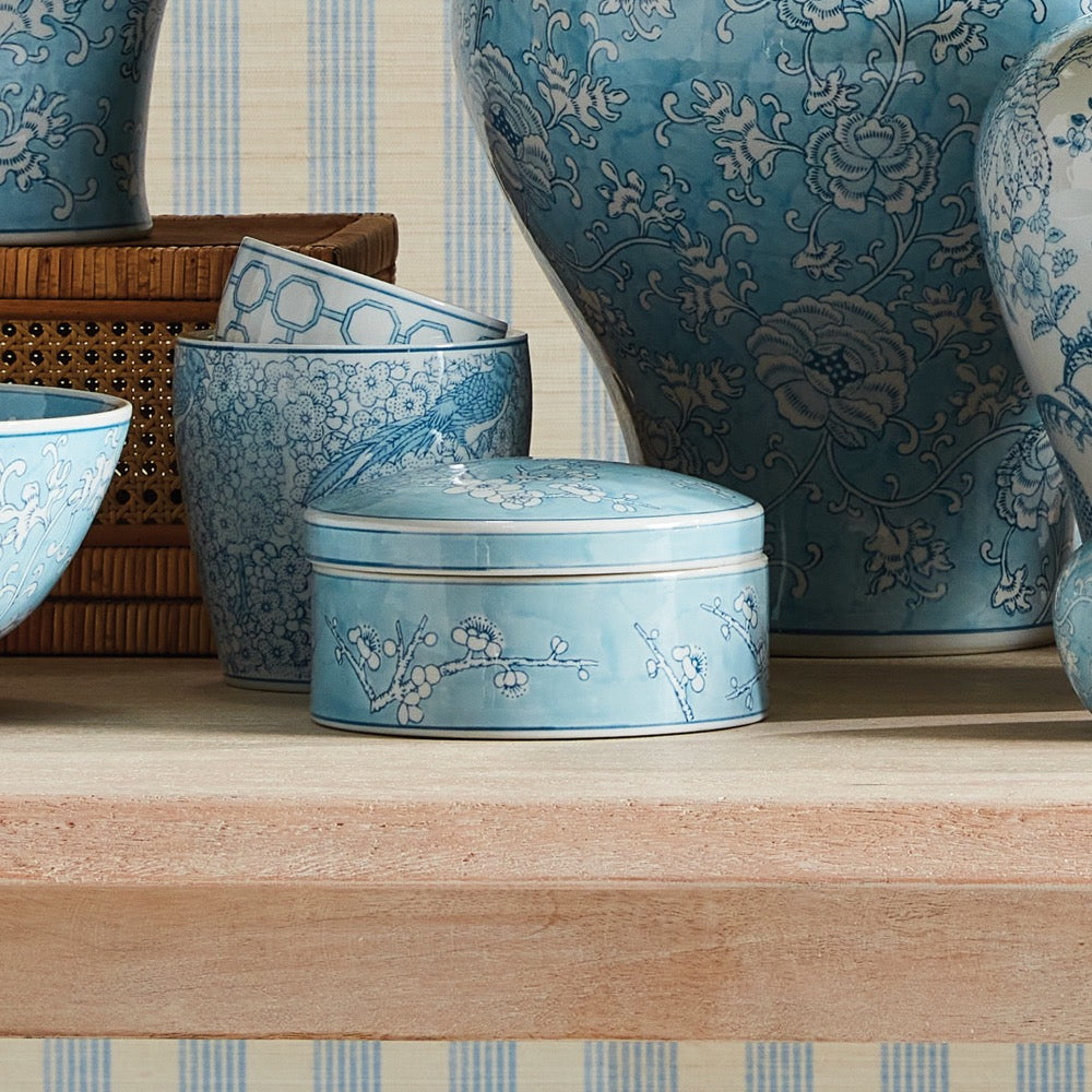 Set of blue ceramic containers with floral patterns on a wooden surface.