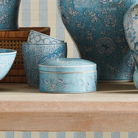 Set of blue ceramic containers with floral patterns on a wooden surface.
