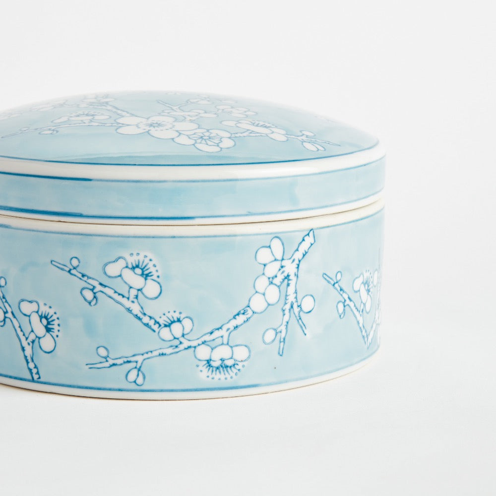 Ceramic box with floral design on a light blue background
