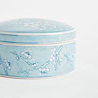 Ceramic box with floral design on a light blue background