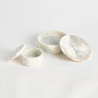 Three marble-patterned marble bowls on a light gray background