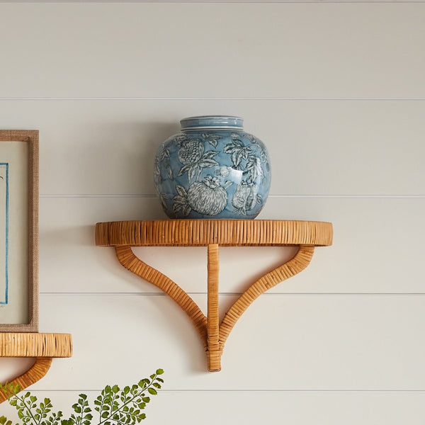 Blue decorative jar on a wooden shelf against a white wall