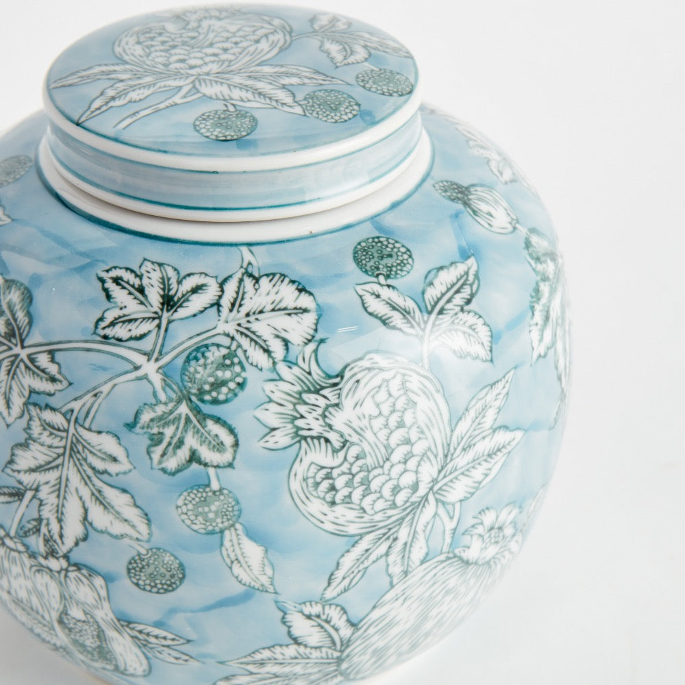 Decorative ceramic jar with floral patterns on a light blue background