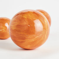 Close-up of a glossy orange sphere on a white background