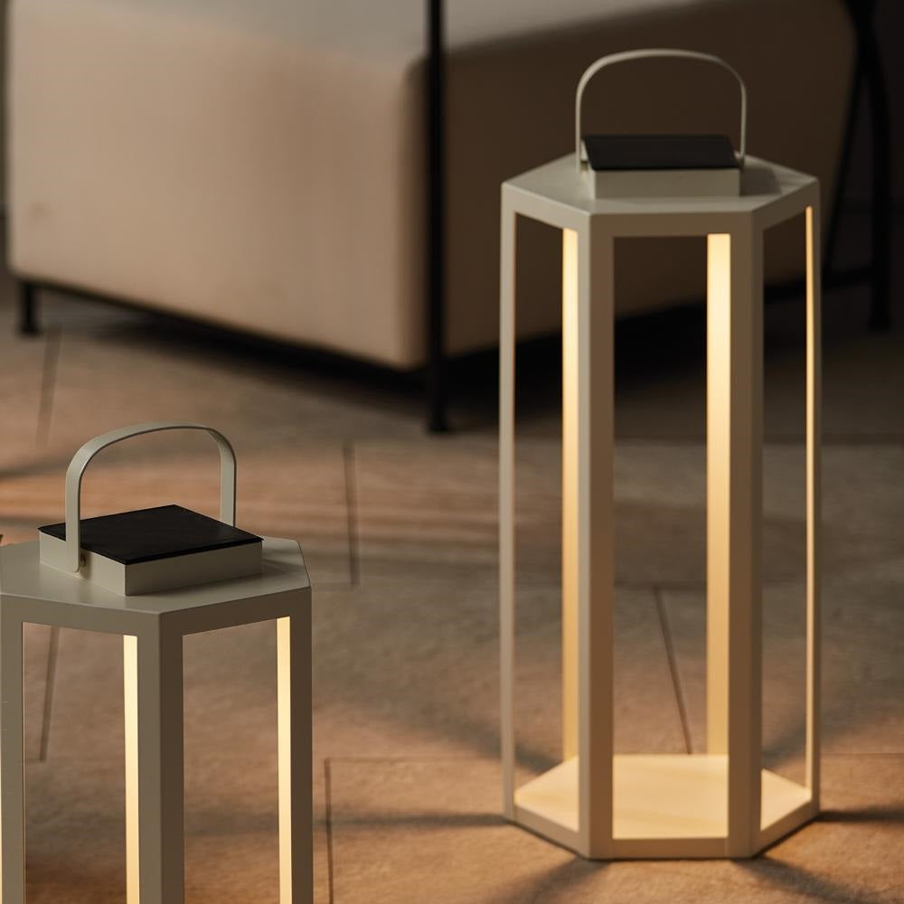 Two hexagonal outdoor lamps with handles on a wooden floor.