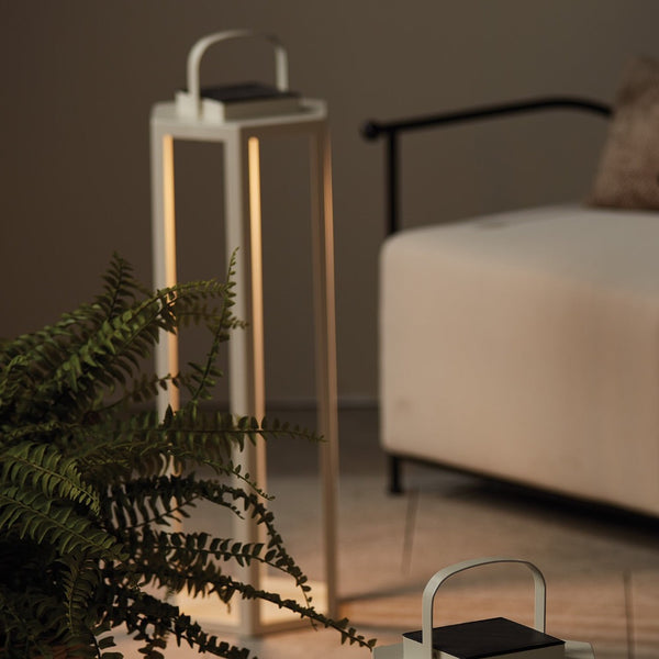 Solar-powered lantern with a plant and chair in the background