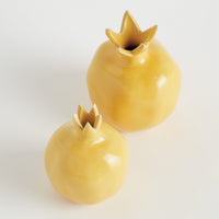 Two yellow ceramic pomegranate-shaped vases on a white background