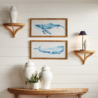 Wall with framed whale art, shelves, and decorative items against a white wooden panel background