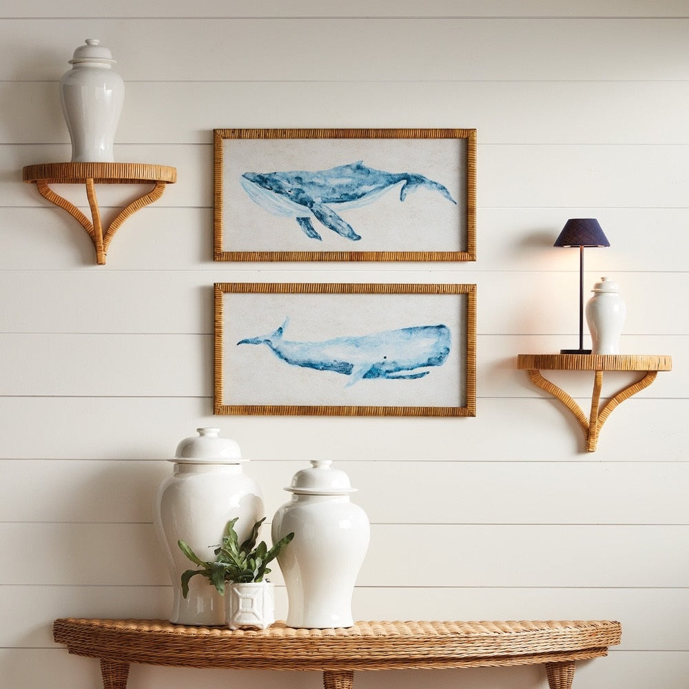 Wall with framed whale art, shelves, and decorative items against a white wooden panel background