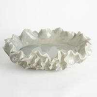Decorative ceramic bowl with ruffled edge on a white background