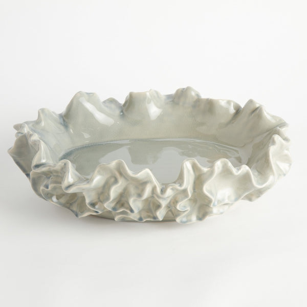 Decorative ceramic bowl with ruffled edge on a white background