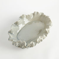 Decorative ceramic dish with ruffled edge on a white background