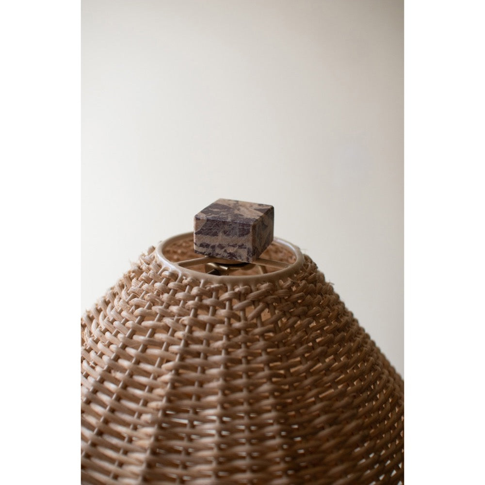 Woven basket with a wooden block on top against a plain background