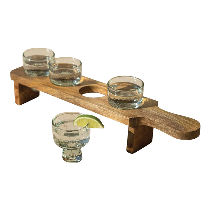 Wooden shot glass holder with four clear glasses on a white background