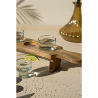 Wooden tray with glasses of water and a lime wedge on a textured surface.
