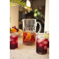 Pitcher and glasses of iced tea with fruit on a table