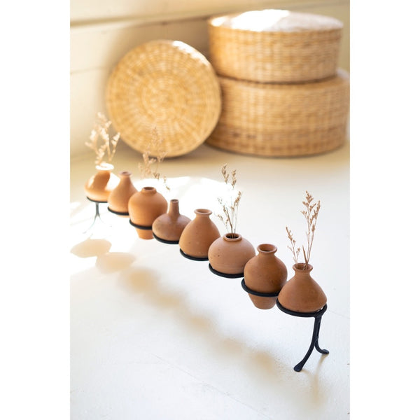 eight rounded clay vessels iron base 