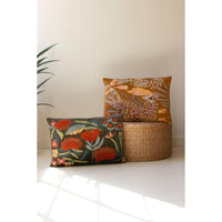 Two floral-patterned cushions and a woven basket on a light surface with a neutral background.