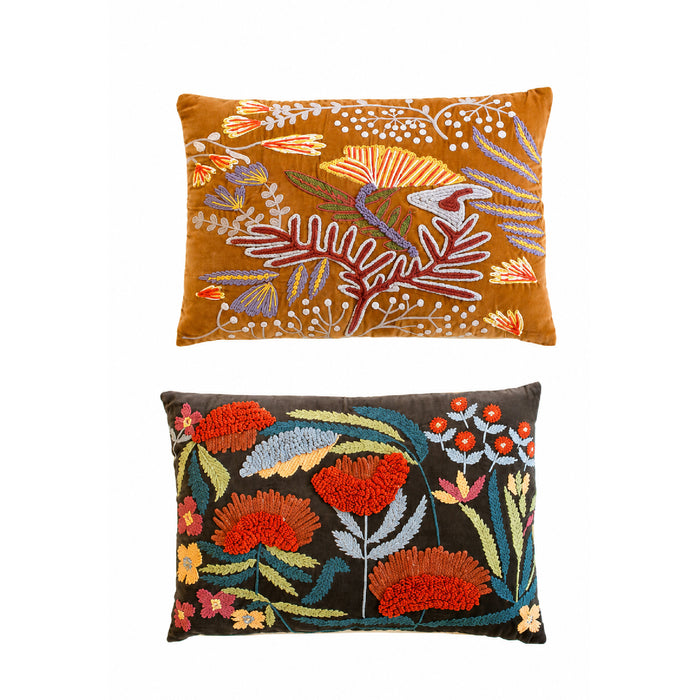 Two decorative embroidered throw pillows shown against a plain white background. The top pillow has a mustard-yellow velvet base with multicolor floral and botanical embroidery.