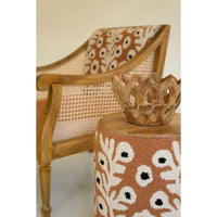 Wooden armchair and side table with floral patterns in a room setting