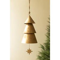 A rustic, tiered metal Christmas tree wind chime hanging from a rope, with a small star-shaped pull, shown against a warm beige background with a pine tree branch on the right.