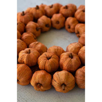 Wreath made of small pumpkins on a light background
