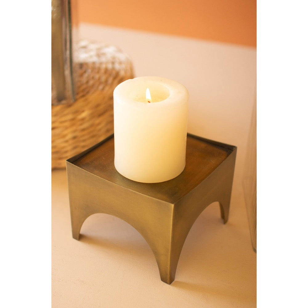 Candle in a decorative holder on a surface with a blurred background