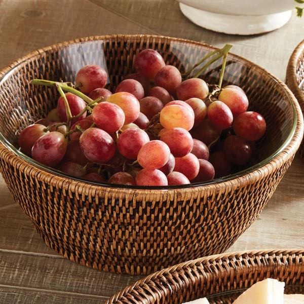 Wicker bowl filled with red grapes on a wooden table