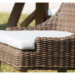 Brown wicker chair with white cushion