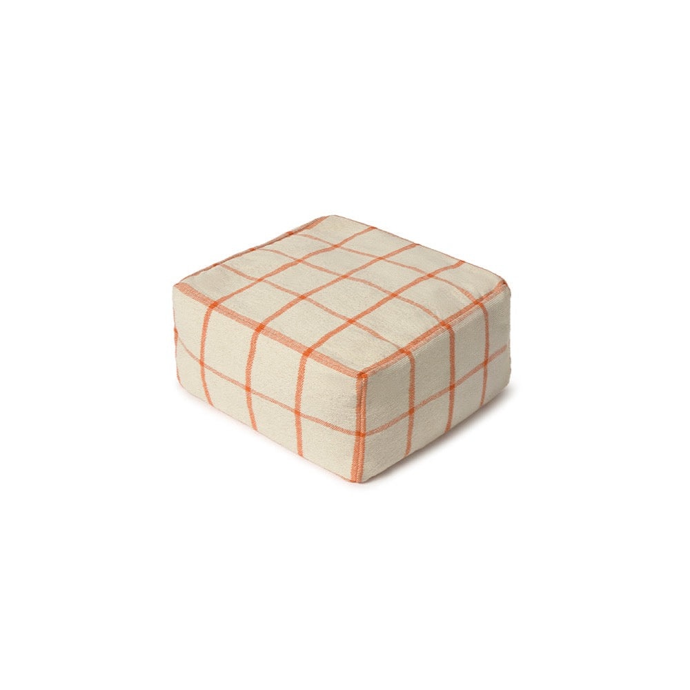 A square pouf ottoman with a cream-colored fabric upholstery and a thin orange grid plaid pattern, shown on a plain white background.