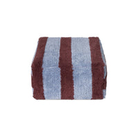 A folded plush pouf with alternating vertical stripes of dusty blue and dark brown, shown against a plain white background.