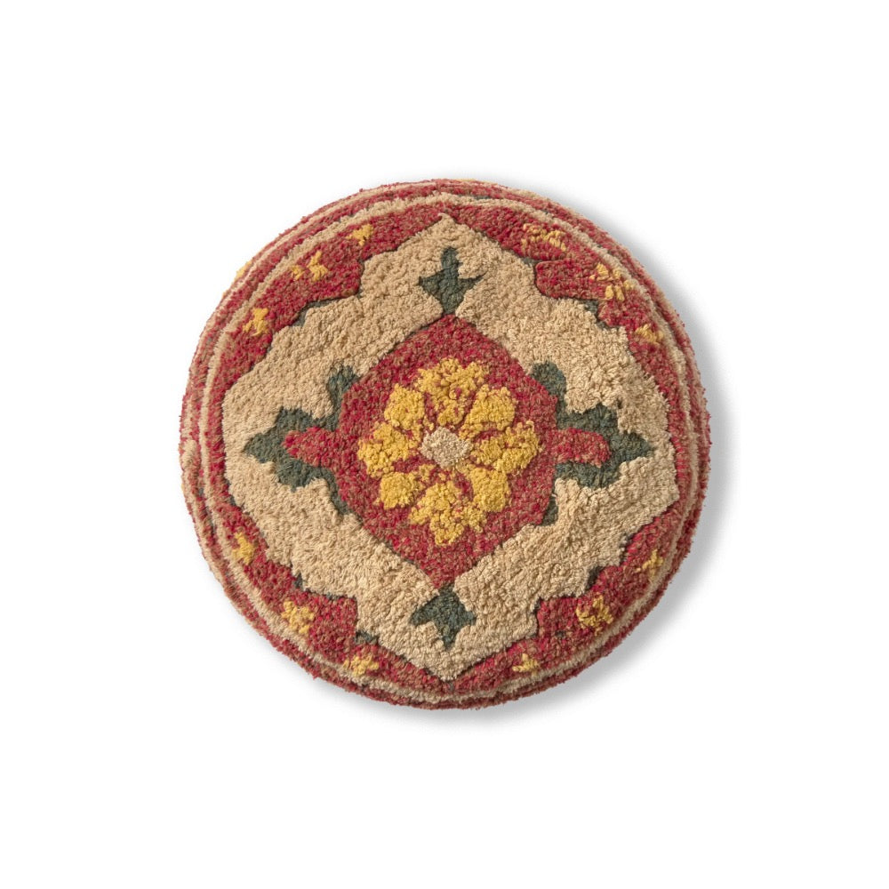 A round, low-pile area rug with a traditional geometric medallion pattern in beige, red, yellow, and green, shown from a top-down perspective on a white background.