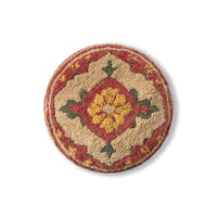 A round, low-pile area rug with a traditional geometric medallion pattern in beige, red, yellow, and green, shown from a top-down perspective on a white background.