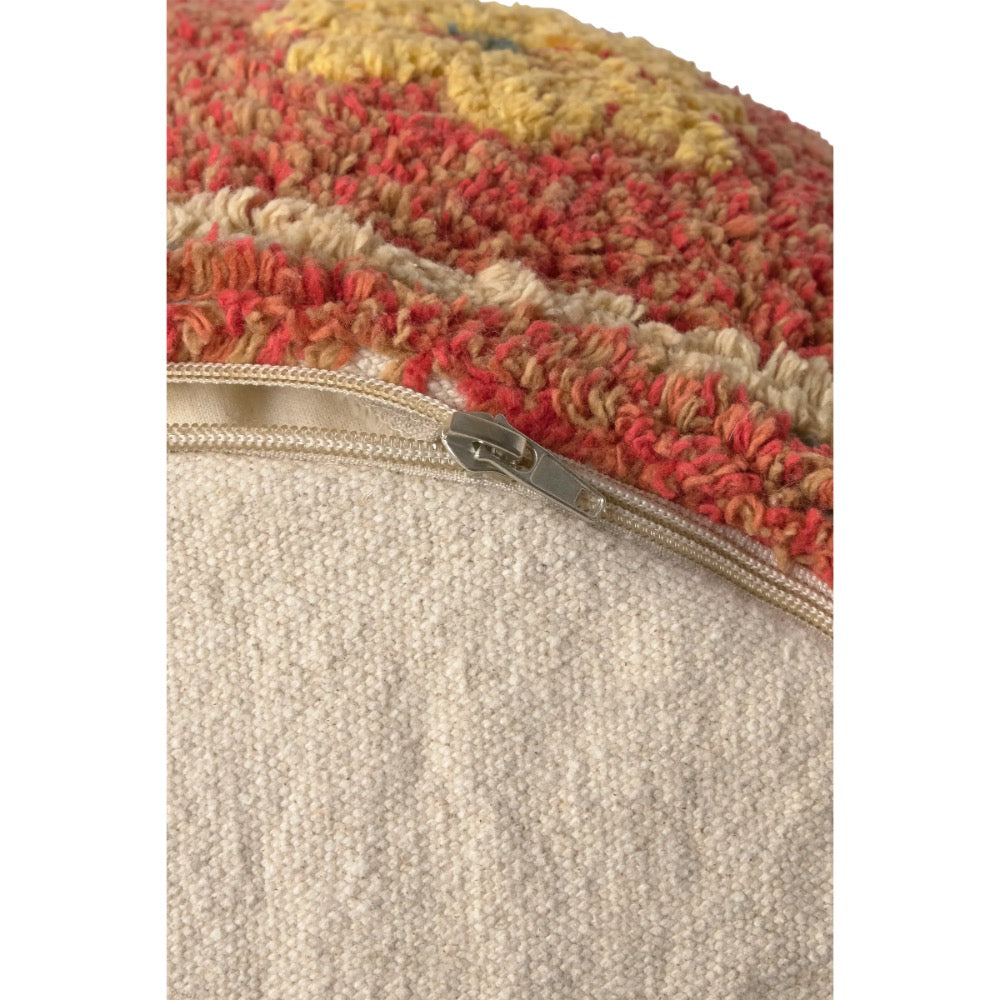 Close-up of a textured throw pillow cover with a colorful chunky knit top section in red, yellow, and beige, and a solid beige woven bottom section with a silver zipper.