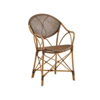 The Kenian Pierre Rattan Chair features a curved backrest, woven seat, and bamboo-style natural rattan frame.