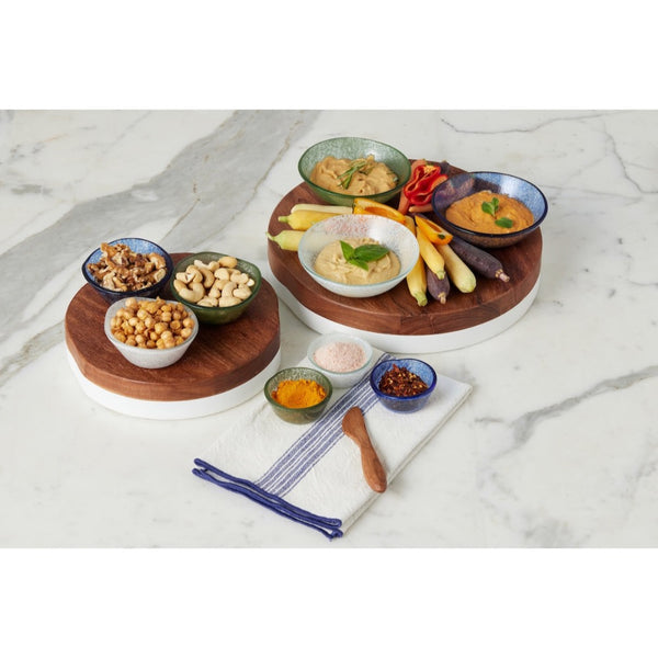 Set of small bowls with snacks on a marble surface