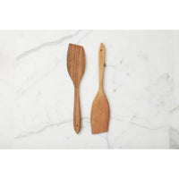Two wooden spatulas on a marble surface