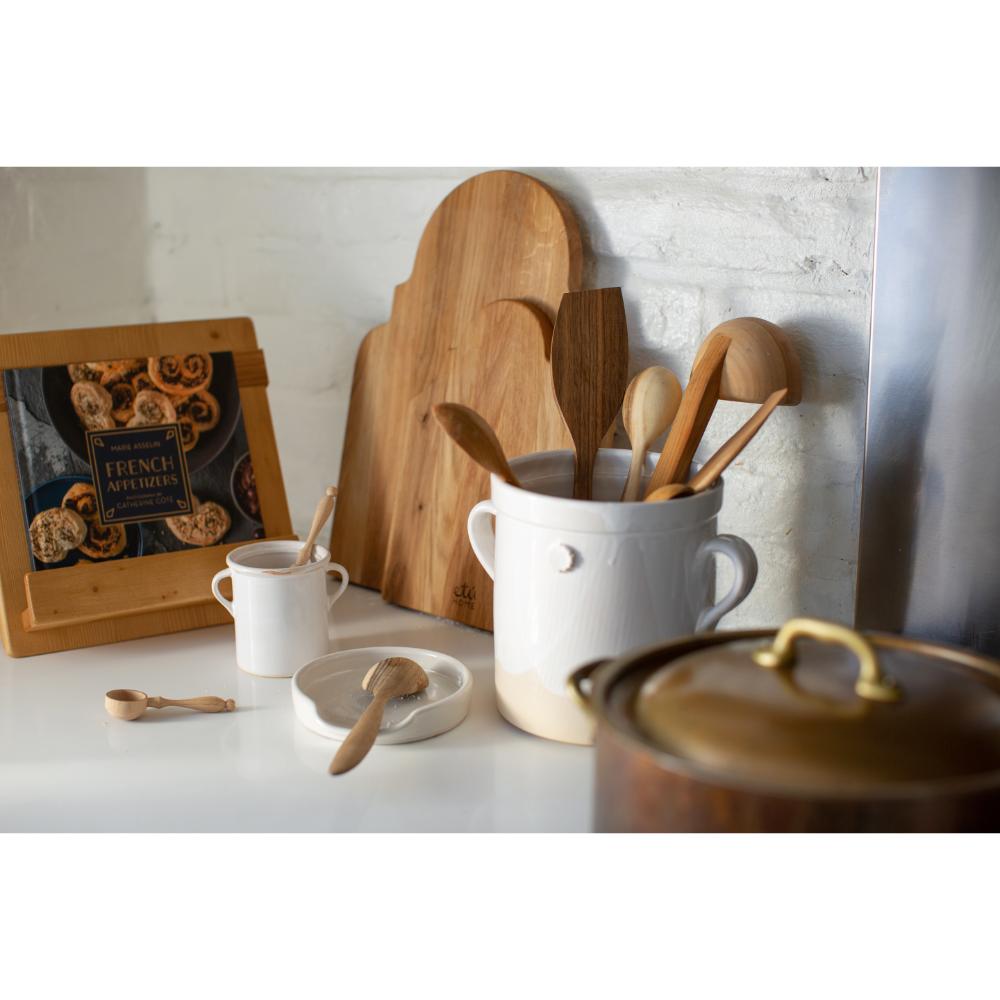 Kitchen utensils and items on a countertop with a neutral background