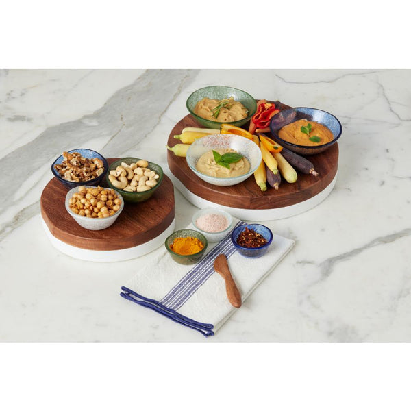 Set of round wood and white serving boards with snacks on a marble surface