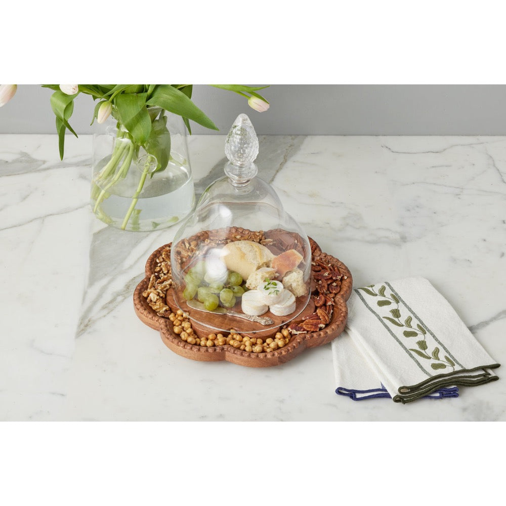 Decorative dish with food on a marble surface with a vase of flowers in the background