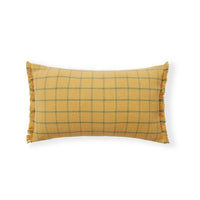 A rectangular throw pillow in a textured mustard yellow fabric with a green windowpane plaid pattern and fringed edges, shown on a plain white background.