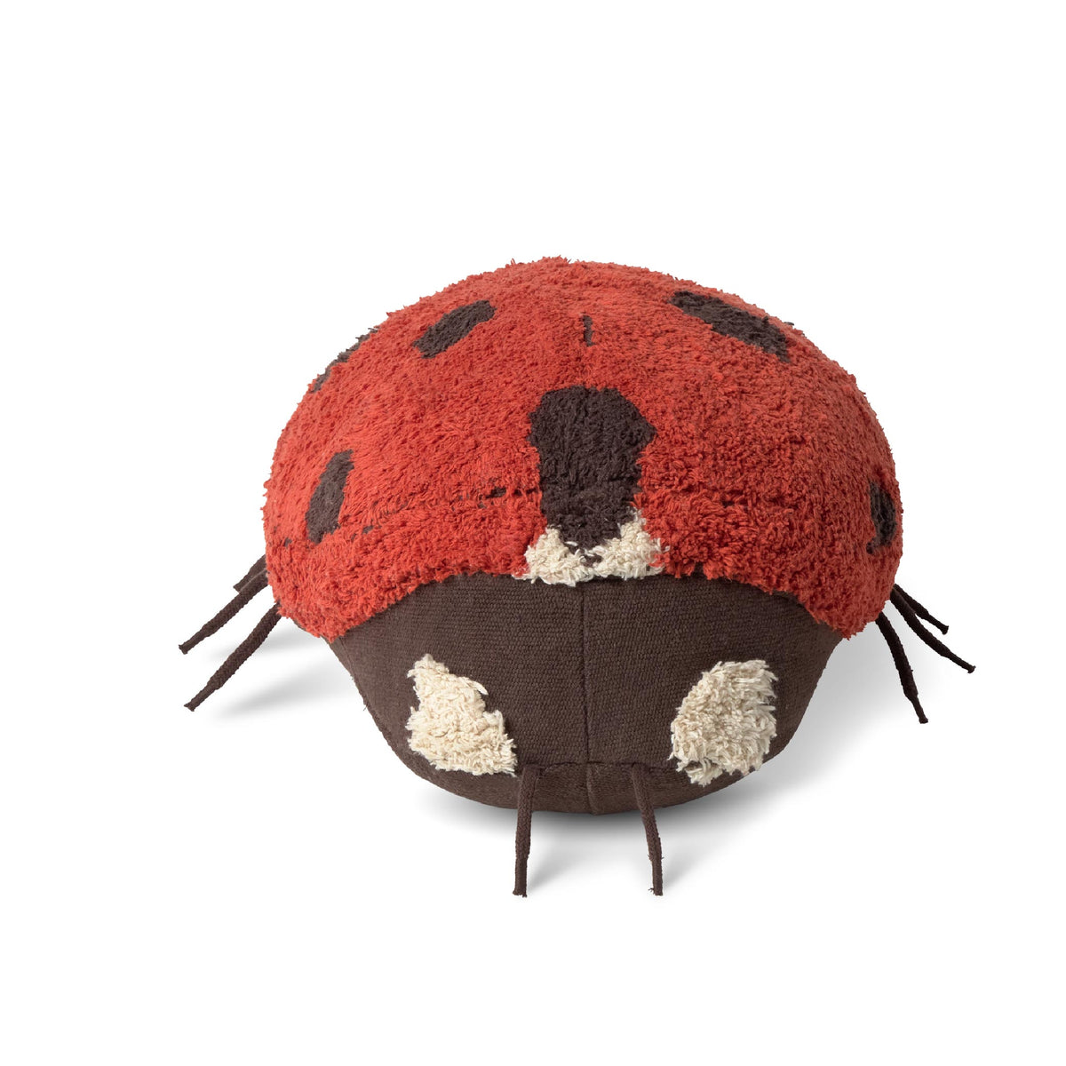 A plush ladybug cushion or pouf with a red fuzzy top, dark brown underside, cream spots, and dark brown legs, photographed on a clean white background.