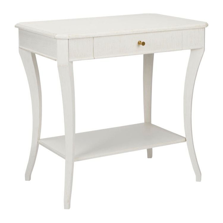 The Sanibel Console Table by Phillips Scott, available in a white finish, features polished brass hardware that complements its single drawer and lower shelf, adding a touch of traditional style.