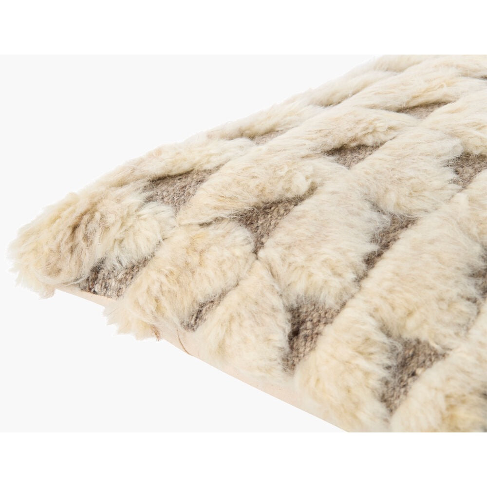 A close-up of a textured throw blanket with a chunky braided or woven pattern in cream and taupe.