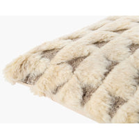 A close-up of a textured throw blanket with a chunky braided or woven pattern in cream and taupe.